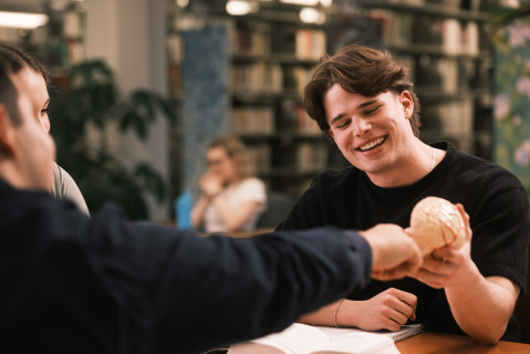 Un étudiant tienne un crâne dans ses mains