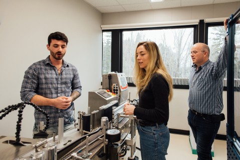 Au cœur de l’action près de la machine de mise en canette de liquides du Cégep de Jonquière.